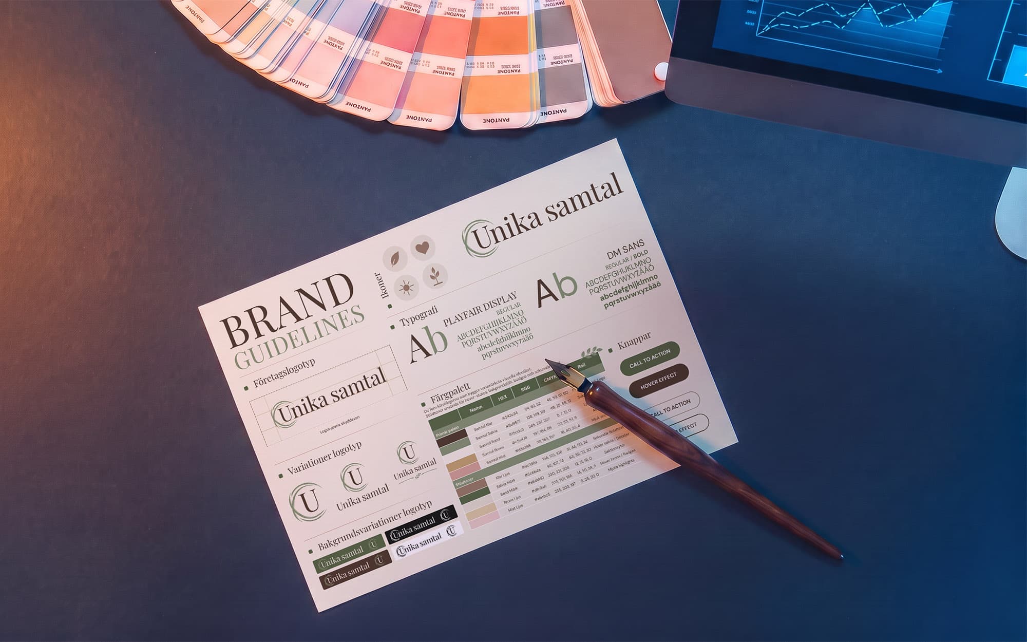 Ett blad ur brand guidelines-dokumentet fotograferat på ett skrivbord bredvid en Pantone-solfjäder och en reservoarpenna. Bladet visar logotypen med utsatt skyddszon, logotypvarianter, varianter mot olika bakgrunder, ikoner, typografin Playfair Display och DM Sans, en färgpalett med namn, hex- och RGB-värden, samt knappar i olika lägen.
